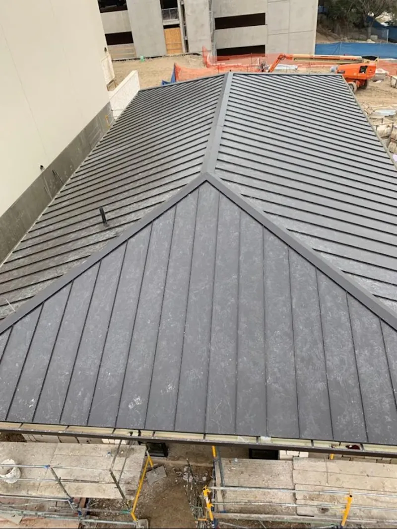 Commercial metal roof construction with crane equipment in Avocado Heights